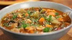 a white bowl filled with soup on top of a wooden table