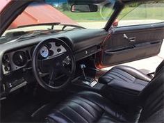 the interior of an old car with black leather seats