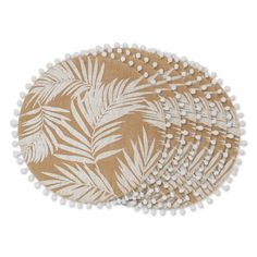 three round placemats with white pom poms on the sides and palm leaf print