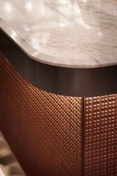 a close up of a marble top on a wooden table with brown and black trim