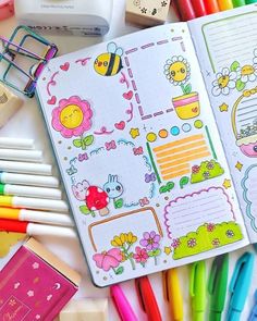 an open notebook with stickers on it next to colored markers and crayons