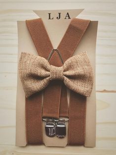 the bow tie and suspenders are on display in front of a card that says j u