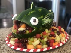 a fish made out of fruit on top of a plate with grapes and watermelon