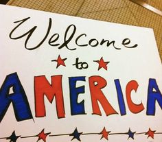 a welcome to america sign with red, white and blue stars