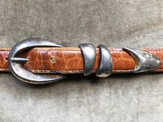 Italian calfskin leather belt with croc/alligator embossed texture. Hardware and buckle with tarnished silver tone finish.  Size M. Good used condition; shows areas of wear and distress. Linda Allard/ Ellen Tracy. Fits approx 27"-31" waist on 5 notches. Recommended for 27"-30" waist.  a tad slimmer than 1 wide. Total length: 36" Womens Belt, Western Rustic, Western Buckles, Body Adornment, Tarnished Silver, Ellen Tracy, Suspender Belt, Fall Shopping, Belts For Women