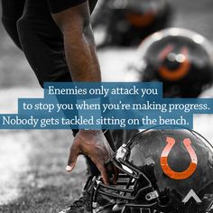 a football player holding his helmet on the sideline with an orange and black quote