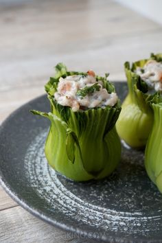 two pieces of celery on a black plate