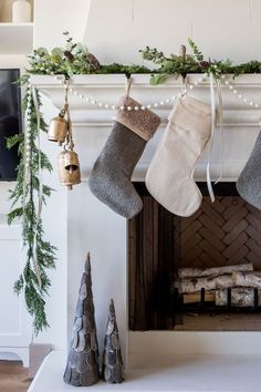 stockings hanging from a mantel with christmas decorations