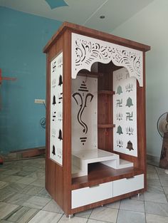 a wooden cabinet with designs painted on the front and sides, in a room with blue walls