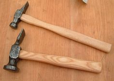 two hammers are sitting on a wooden table