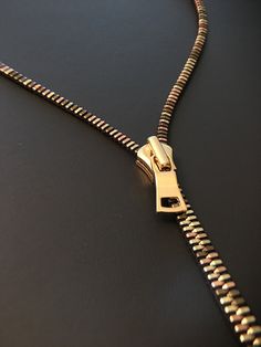 Discover the seamless blend of style and functionality with our unique necklace. Boasting sleek lines and a smooth glide, this piece is designed for effortless elegance. Forget about fumbling with tricky clasps. With our innovative design, you just need to unzip and wear it. It's as simple as that. This necklace not only adds a touch of sophistication to your attire but also offers a hassle-free experience. Experience the ease of elegance. Unzip, wear, and let your style statement speak volumes. With our necklace, fashion is not just about looking good; it's about feeling good too. Reminding me of a chameleon, it looks amazing when wearing apparel colors of brown, orange, yellow, olive and black.  - High polished metal - Zipper teeth are plated gold, rose gold and antique brass in color. - Long Drop Necklace, Zipper Necklace, Necklace Luxury, Thousand Oaks, Pewter Metal, Luxury Necklace, Charm Necklaces, Neck Piece, Fashion Materials