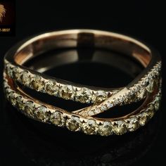 two gold rings with white diamonds on black background