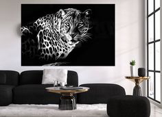 a black and white photo of a leopard on the wall in a living room setting