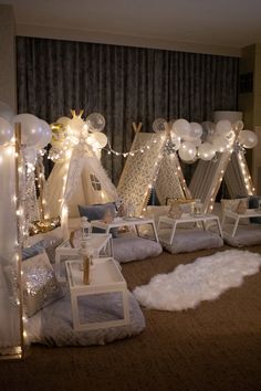 a room filled with lots of white furniture and balloons