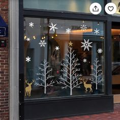 a store front with christmas decorations in the window and snowflakes on the windows