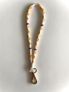 a white lanyard with an orange and yellow bead