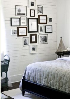 a bed sitting in a bedroom next to a window with pictures on the wall above it