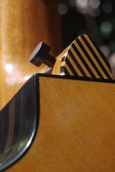 a close up of a skateboard on top of a wooden board holder with black and white stripes