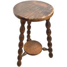 an old wooden stool with two legs and a small round table on one end that is turned upside down