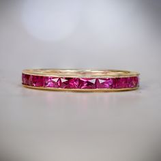 a close up of a pink ring on a white surface