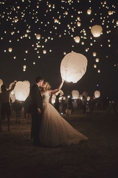 a bride and groom are holding lanterns in the air at night, with text reading sky lanterns - wedding exit chinese lanternes