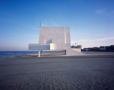 a large white building sitting on top of a sandy beach