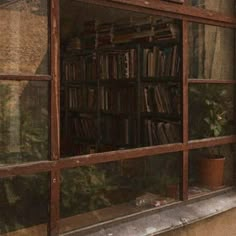 an old window is filled with books and plants