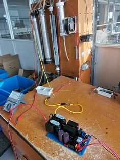 an electrical device is sitting on top of a wooden table with wires running through it