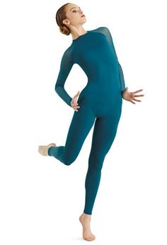 a woman in a blue bodysuit is standing with her hands on her hips and arms behind her back