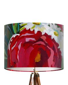 a lamp with a red and white flower on it's shade that is attached to a wooden tripod base