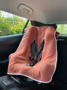 an orange blanket sitting on the back seat of a car