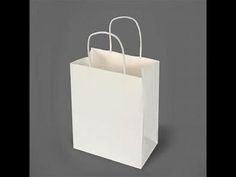 a white paper bag with two handles on a gray background, it appears to be an empty shopping bag