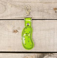 a green keychain with a smiling face on it's front and side