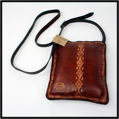 The artisan takes leather from Argentina and works it into fashionable ladies delicate small purses by adding in traditional symbols and designs that give each one a taste of the South American vibe! Each one has a small zipper on the inside to store items, a black interior and are about 7 1/2 to 8" approx. in dimension. They are light in weight  and with an adjustable buckle strap. Enjoy the new look! Rectangular Shoulder Bag With Coin Pocket As Gift, Traditional Brown Pouch For Everyday Use, Rectangular Hand-stitched Coin Purse For Daily Use, Hand-stitched Brown Coin Purse For Daily Use, Leather Hand-stitched Coin Purse For Everyday Use, Brown Hand-stitched Coin Purse For Daily Use, Brown Hand Tooled Coin Purse Gift, Traditional Brown Rectangular Pouch, Vintage Brown Hand Tooled Bag For Everyday Use