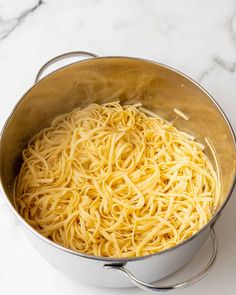 a large pot filled with noodles on top of a white counter