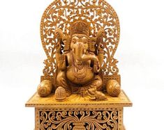 an elephant statue sitting on top of a wooden stand