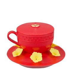 a red cup and saucer with yellow flowers on it