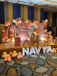 a decorated stage with balloons and decorations for a one - birthday party at navya