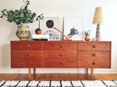 a large wooden dresser sitting on top of a hard wood floor next to a lamp