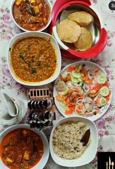 several bowls of food are arranged on a table