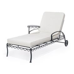 an outdoor chaise lounge chair with white cushions and black metal frame, viewed from the side