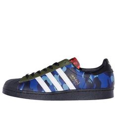 The Adidas BAPE x Superstar 'Mixed Camo' is a special edition sneaker designed in collaboration with the iconic streetwear brand, BAPE. This limited edition shoe celebrates the 50th anniversary of the classic Adidas Superstar silhouette with its unique mismatched camo-print paneling in purple, red and blue. The contrasting hues are offset by a solid black finish on the heel tab and rubber shell toe, while the jumbled color blocking is accompanied by asymmetrical branding elements from both Adidas and BAPE. At the bottom of each lace bed, there is a metallic BAPE dubrae for added flair. (SNKR/Unisex) Adidas Custom Sneakers With Vulcanized Sole For Streetwear, Adidas Sneakers With Vulcanized Sole For Streetwear, Adidas Logo Custom Low-top Sneakers For Streetwear, Adidas Urban Streetwear Sneakers, Adidas Skate Shoes With Abzorb Midsole For Streetwear, Adidas Sneakers With Boost Midsole For Streetwear, Custom Logo Print Sneakers For Streetwear, Adidas Casual Custom Sneakers For Streetwear, Adidas High-top Custom Sneakers For Streetwear