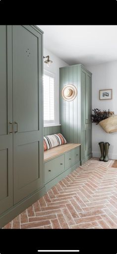 a room with green cupboards and a brown rug on the floor in front of it