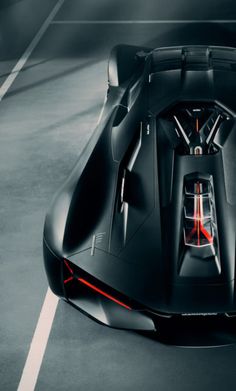 a black sports car parked in a parking lot with its hood up and lights on