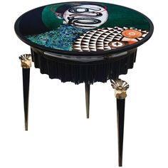 a table with an artistic design on the top and two legs that are painted black