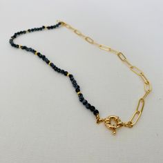 This versatile asymmetrical necklace offers three distinct looks in one stunning piece. The necklace is divided into two halves, providing a striking contrast between round onyx gemstones and a paper clip gold chain. One half of the necklace features round onyx gemstones, known for their deep black hue and natural beauty. The gemstones are delicately threaded together, creating a beaded strand that adds an element of elegance and color to the design. The lapis gemstones exude a sense of sophisti Elegant Black Link Jewelry, Everyday Black Necklace With Cable Chain, Elegant Black Necklace With Cable Chain, Black Link Necklace With Adjustable Chain, Black Necklace With Adjustable Chain, Black Chain Link Necklace With Adjustable Chain, Minimalist Black Chain Link Jewelry, Modern Black Link Necklace, Chic Black Chain Link Necklace