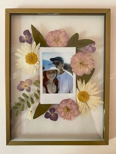 a photo frame with flowers and leaves in it