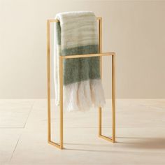 a towel rack with two towels on it and one folded up in the same color