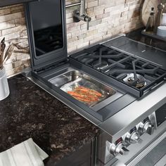 a stove top oven sitting inside of a kitchen next to a counter with a pot on it