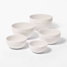 four white bowls sitting next to each other